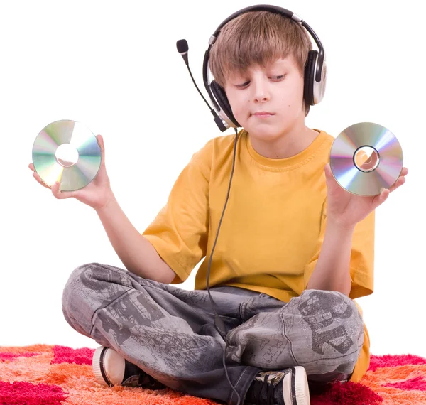 Маленький улыбающийся мальчик слушает музыку в наушниках — стоковое фото