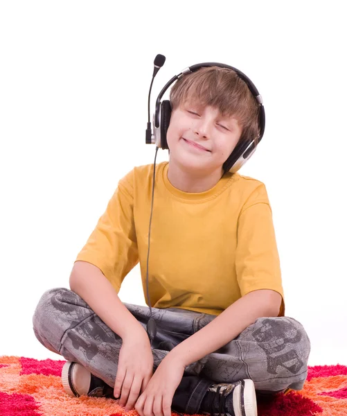 Menino sorridente ouvindo música em fones de ouvido — Fotografia de Stock