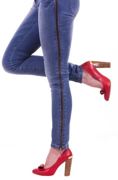 Sexy womanish leg in blue jeans and red shoes — Stock Photo, Image
