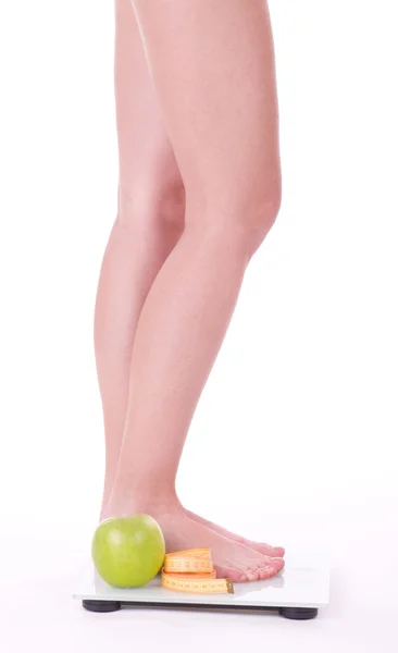 女性の足と白で隔離されるスケール上のリンゴ — ストック写真