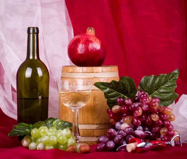 Состав с вином, виноградом, гранатом и бочкой — стоковое фото