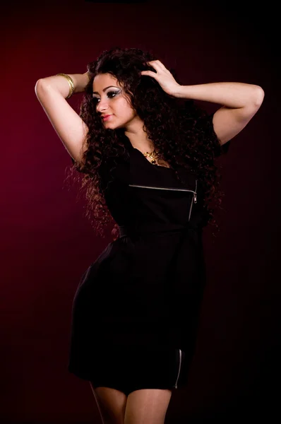 Schöne junge Frau im Kleid auf dunklem Hintergrund. — Stockfoto