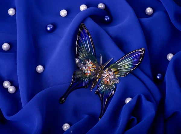 Beautiful butterfly on dark blue fabric — Stock Photo, Image