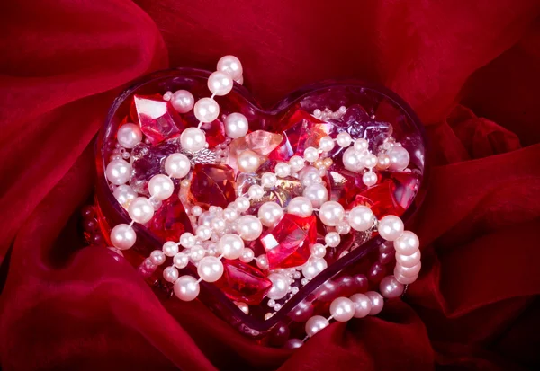 Krásné světlé barevné kameny a pearl v srdci — Stock fotografie