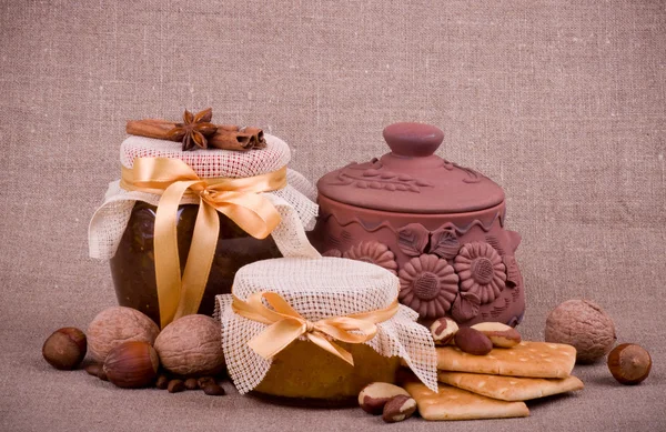 Tasty jam, cupcakes, clay pot and nuts — Stock Photo, Image