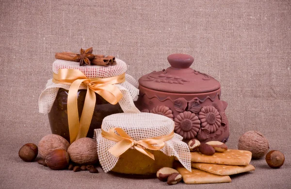 stock image Tasty jam, cupcakes, clay pot and nuts