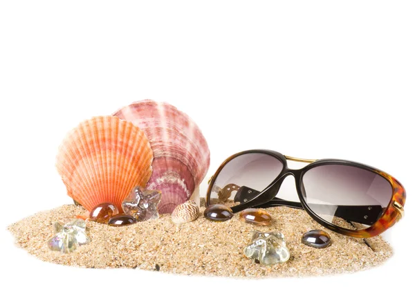 Bellissimo guscio esotico, cristalli e bicchieri sulla sabbia — Foto Stock