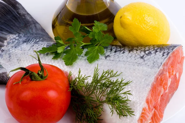 Piece of a salmon with lemon, tomato and olive oil — Stock Photo, Image