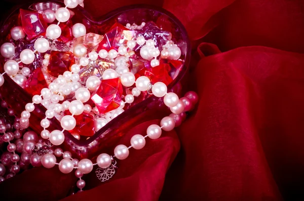 Bright colorful stones and pearl in heart — Stock Photo, Image