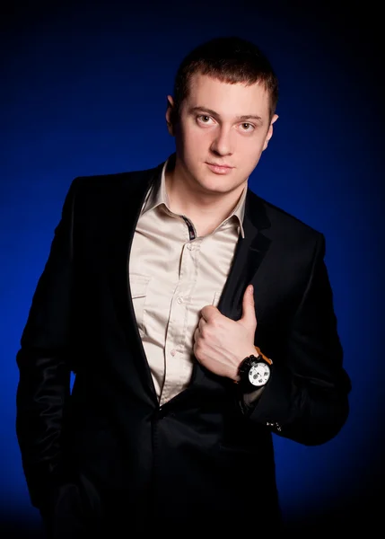 Homem bonito com relógio em um fundo azul — Fotografia de Stock