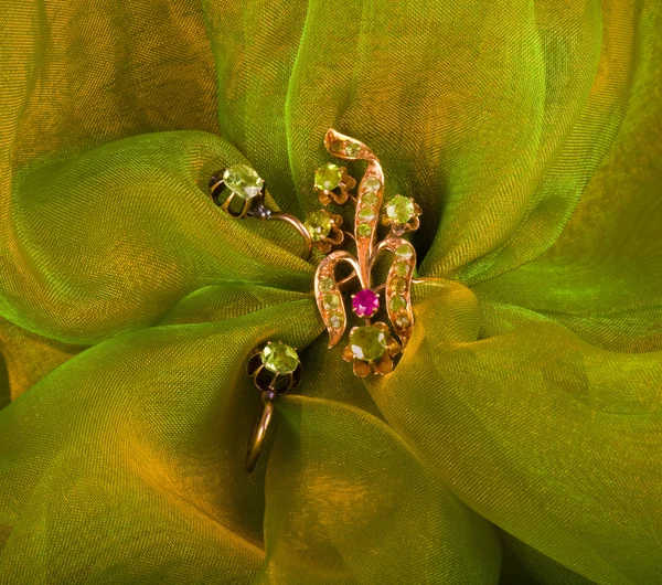 Gioielli dorati su sfondo verde — Foto Stock