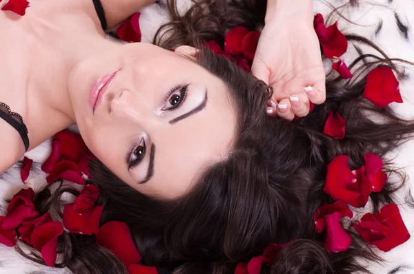 Vacker sexig tjej med rosenblad i hör. Studio skott. — Stockfoto