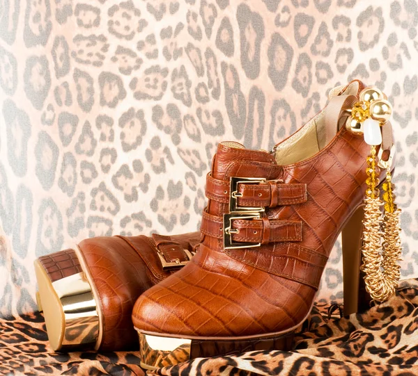 Sexig moderiktiga skor med gyllene smycken på bakgrund. — Stockfoto