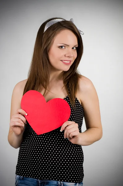 Krásná mladá žena s červeným srdcem — Stock fotografie