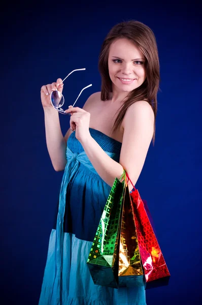 Mulher segurando sacos de compras e sorrindo — Fotografia de Stock