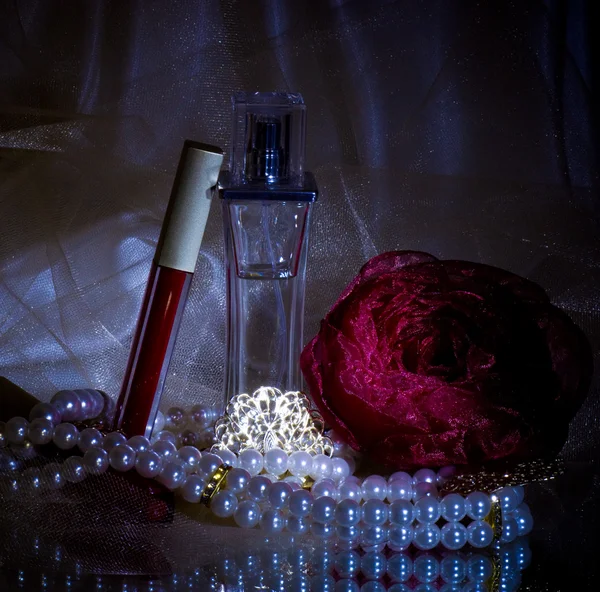 Frascos de perfume, lápiz labial rojo, plumas, rosas y perlas —  Fotos de Stock