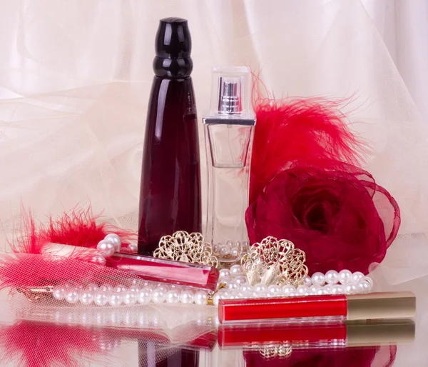 Frascos de perfume, lápiz labial rojo, plumas, rosas y perlas —  Fotos de Stock