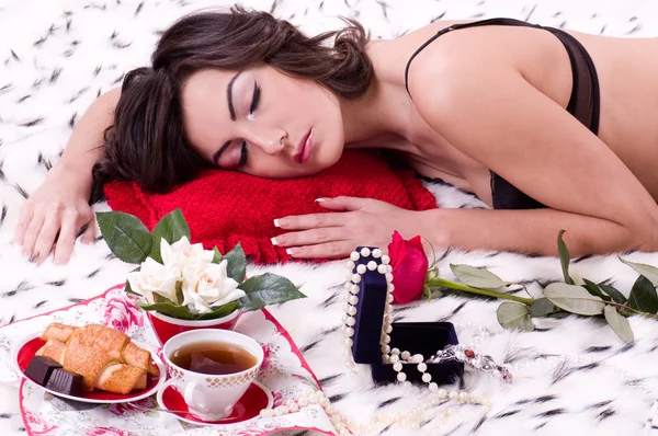 Brunetka kobieta w łóżku z prezenty na Walentynki — Zdjęcie stockowe