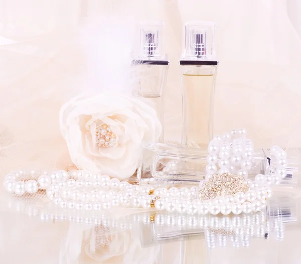 Las hermosas botellas de perfume nupcial, rosa blanca y perlas de perlas — Foto de Stock