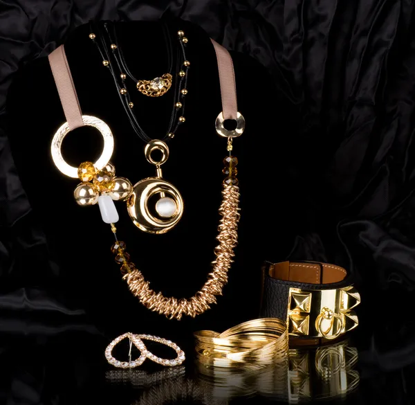 Złota biżuteria na czarnym tle — Zdjęcie stockowe