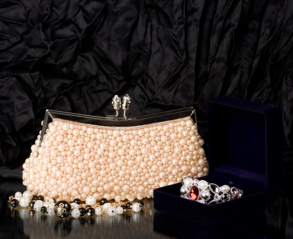 Sexy modieuze handtas met parel sieraden op zwarte achtergrond. — Stockfoto