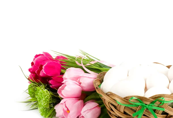 Cesta com ovos de Páscoa e tulipas primavera fundo branco — Fotografia de Stock