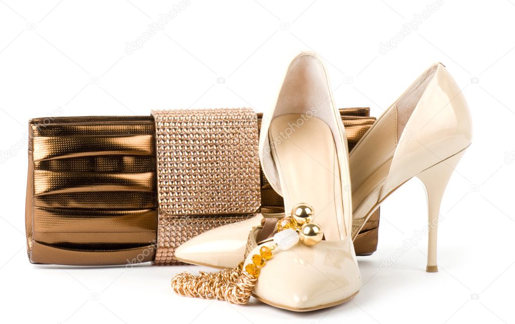 Sexy fashionable shoes with handbag and golden jewelry on white background.