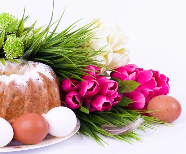 Cesta com ovos de Páscoa e flores de primavera no fundo branco — Fotografia de Stock