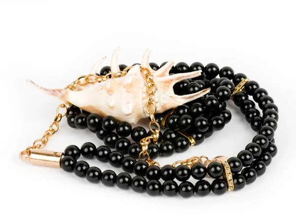 Coquille avec collier de perles sur fond blanc — Photo
