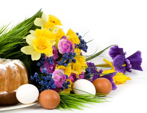 Традиционный пасхальный торт с пасхальными яйцами и весенними цветами — стоковое фото