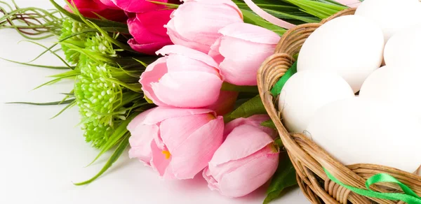 Cesta com ovos de Páscoa e flores de primavera — Fotografia de Stock