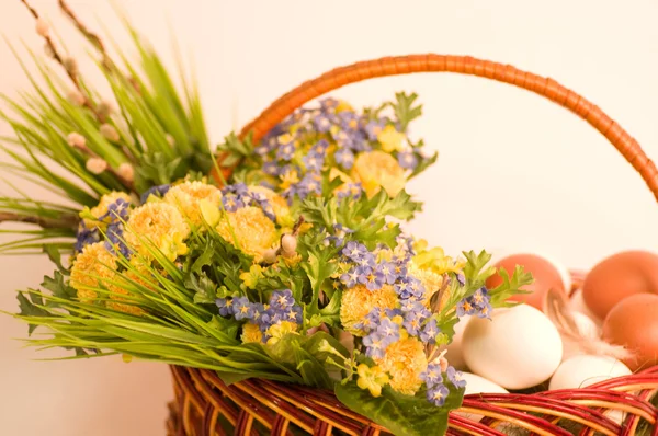 Basket with Easter eggs and spring flowers — Stock Photo, Image