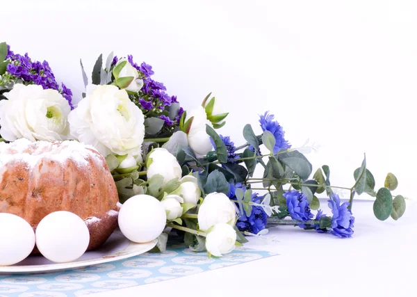 Tradiční velikonoční dort s velikonočními vejci a jarními květy — Stock fotografie