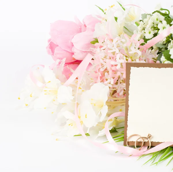 Χρυσά γαμήλια δαχτυλίδια για ένα μπουκέτο λευκά λουλούδια — Φωτογραφία Αρχείου