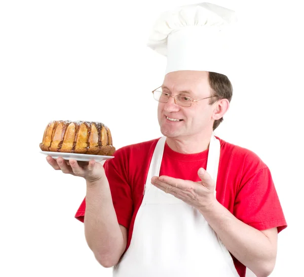 Male cook in uniform and hat with cake chocolate cake — Stock Photo, Image