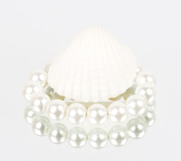 Shell branco com colar de pérolas sobre fundo branco — Fotografia de Stock