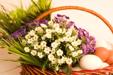 Basket with Easter eggs and spring flowers clipart