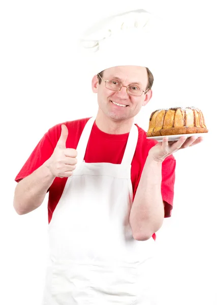 Üniforma ve çikolatalı kek pasta ile şapka erkek aşçı — Stok fotoğraf