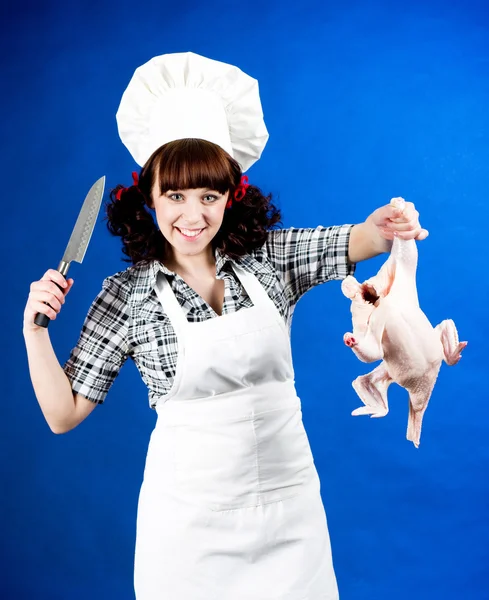Sorrindo feliz cozinheiro mulher detém uma galinha crua — Fotografia de Stock