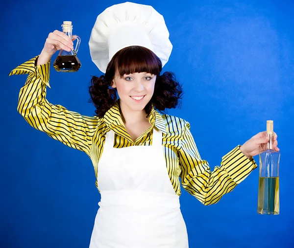 Smiling happy cook woman holds a oils — Stock Photo, Image