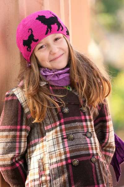 Sorrindo menina de pé perto da coluna no parque — Fotografia de Stock