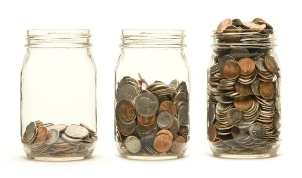 Three glass jars holding coins — Stock Photo, Image