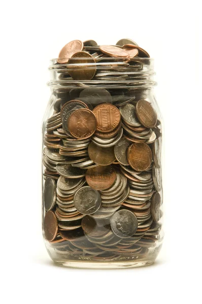 Glass jar overflowing with American coins — Stock Photo, Image