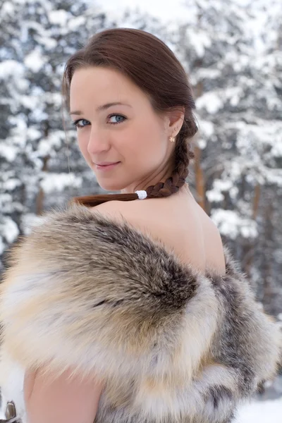 Sexy girl in fox vest on the background of the winter forest — Stock Photo, Image