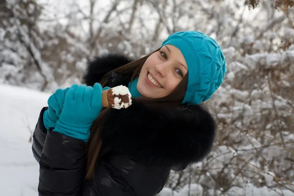 Девушка с мороженым на фоне заснеженного парка — стоковое фото
