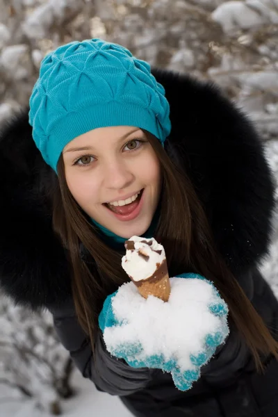 Girl with ice cream on a background of snow-covered park — Stock Photo, Image