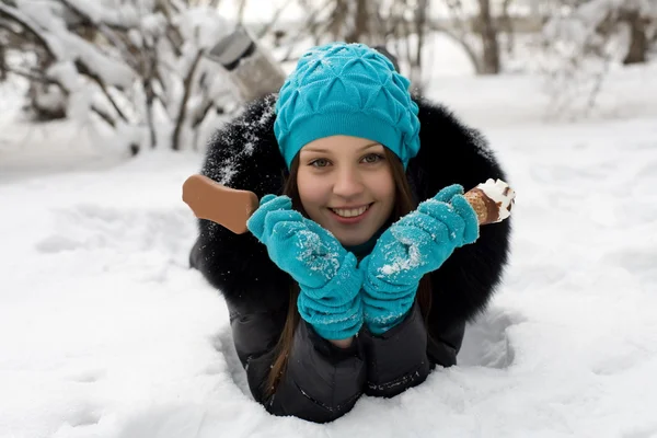 Girl with ice cream on a background of snow-covered park — Stock Photo, Image