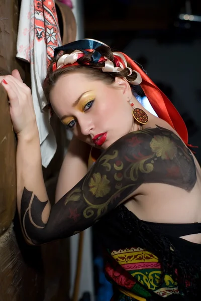 Vacker ung kvinna med ljusa smink och mönstret på huden — Stockfoto