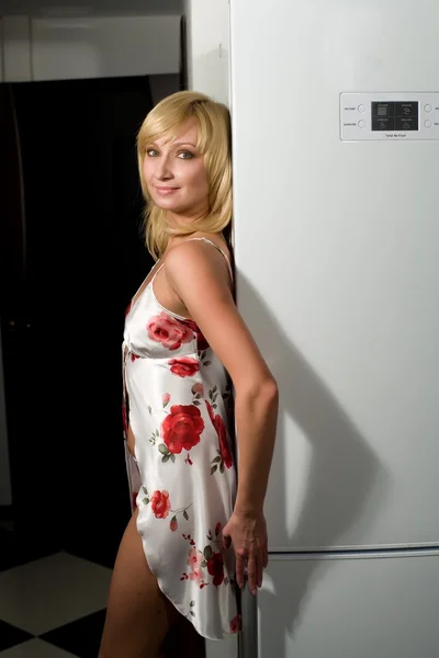 Sexy Blondine im Negligé auf dem Hintergrund des Kühlschranks — Stockfoto