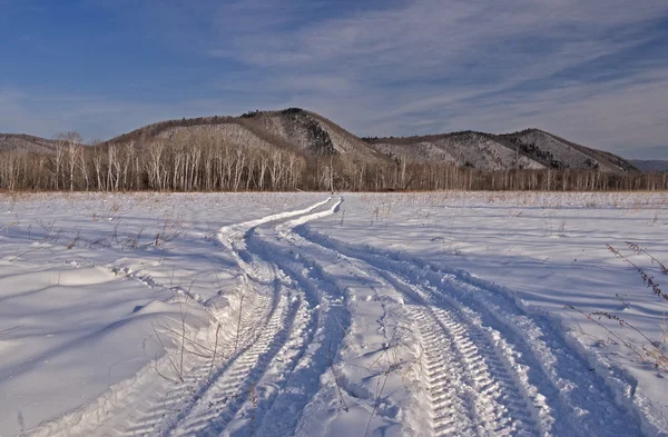 Auto trace op een veld met sneeuw bedekte — Stockfoto